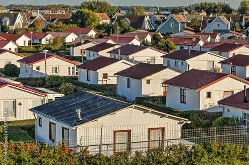 's-Gravenzande, The Netherlands, October 18, 2022: park with white wooden holiday homes in the narrow strip between the greenhouses of Westland and the Northsea coast photo