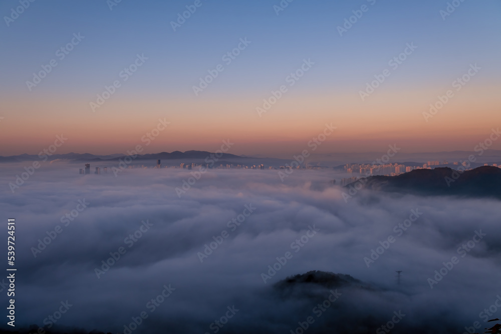 Scenic view of the city under the fog during sunrise