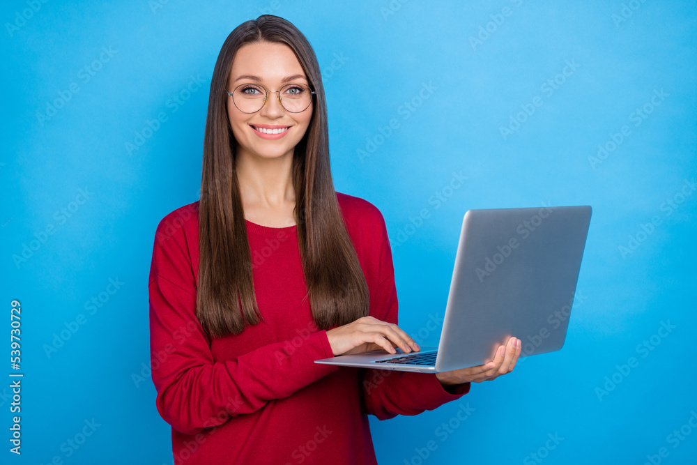 Photo of seo millennial lady hold laptop wear eyewear red shirt isolated on blue color background Photo of seo millennial lady hold laptop wear eyewear red shirt isolated on blue color background