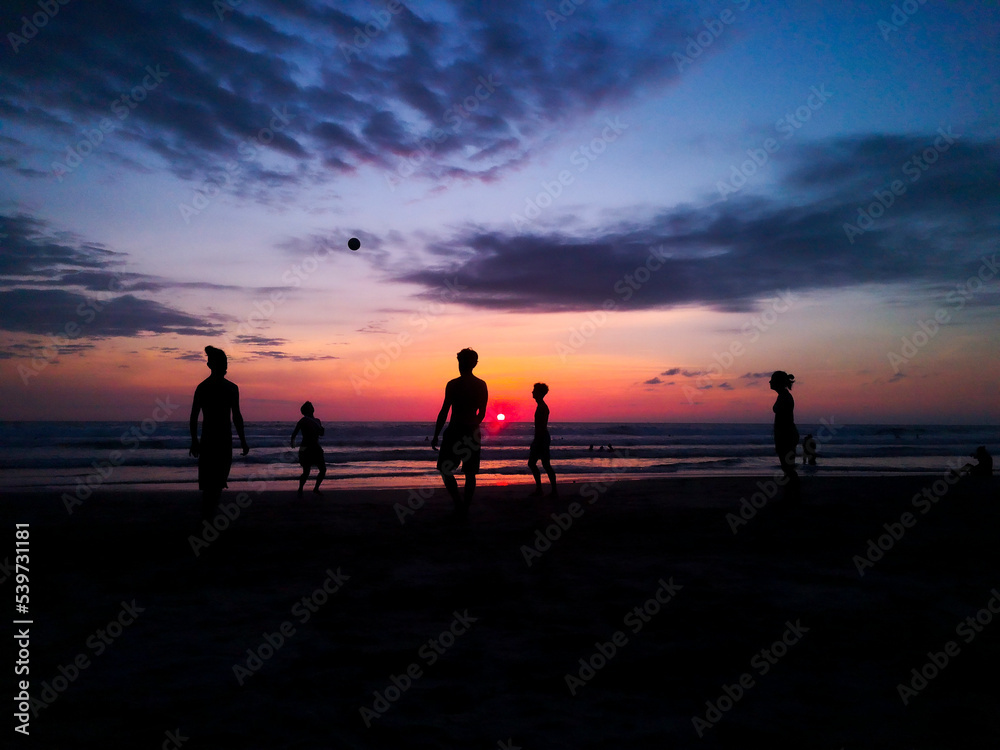 football on the beach during sunset