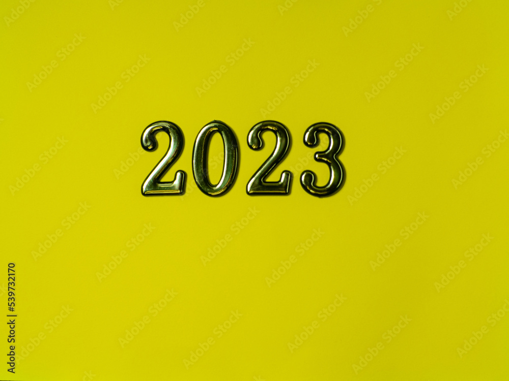 2023 on yellow background with copy space. Greeting card - happy new year with numbers 2023 on yellow background. Bright holiday concept. Top view. Flat lay 2023 on yellow background with copy space. Greeting card - happy new year with numbers 2023 on yellow background. Bright holiday concept. Top view. Flat lay