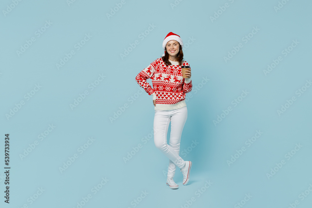 Full body young merry woman in red sweater Santa hat posing hold takeaway delivery craft paper cup coffee to go isolated on plain pastel light blue cyan background Happy New Year 2023 holiday concept Full body young merry woman in red sweater Santa hat posing hold takeaway delivery craft paper cup coffee to go isolated on plain pastel light blue cyan background Happy New Year 2023 holiday concept