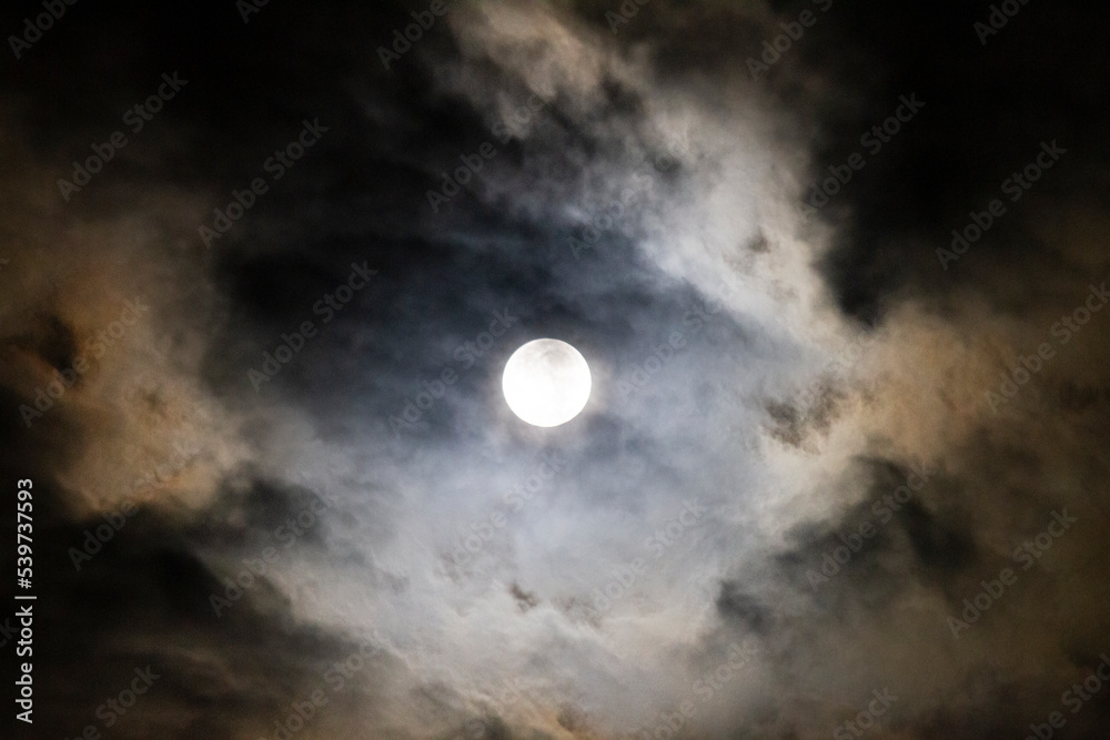 Full Moon in the night sky with clouds