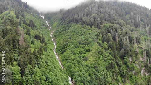  Aerial view of mountains in Rize, Turkey. The river flowing down from high mountains.  The camera flies from top to bottom