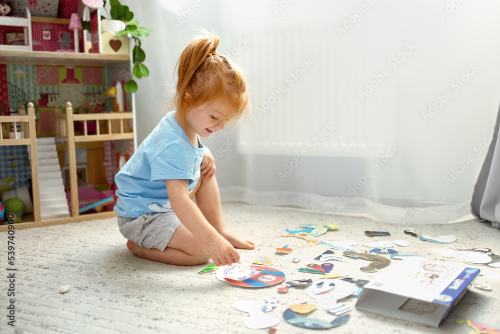 cute red-haired girl learns emotions in the process of playing in a home environment. 