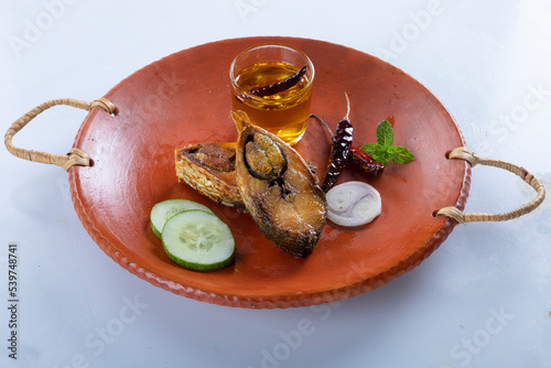 ilish panta Bengali new year festive dish. Boishakh panta ilish with green chilli and onion. Panta bhat is popular among Bengali's in India and Bangladesh. into clay plate seving bowl shanki or sanki photo