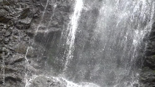  Falling water, slow motion. Water flows over the rocks, close-up