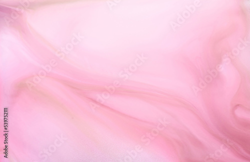Delicate pink alcohol ink abstract background, watercolor marble texture. Wavy stains of acrylic paint under water