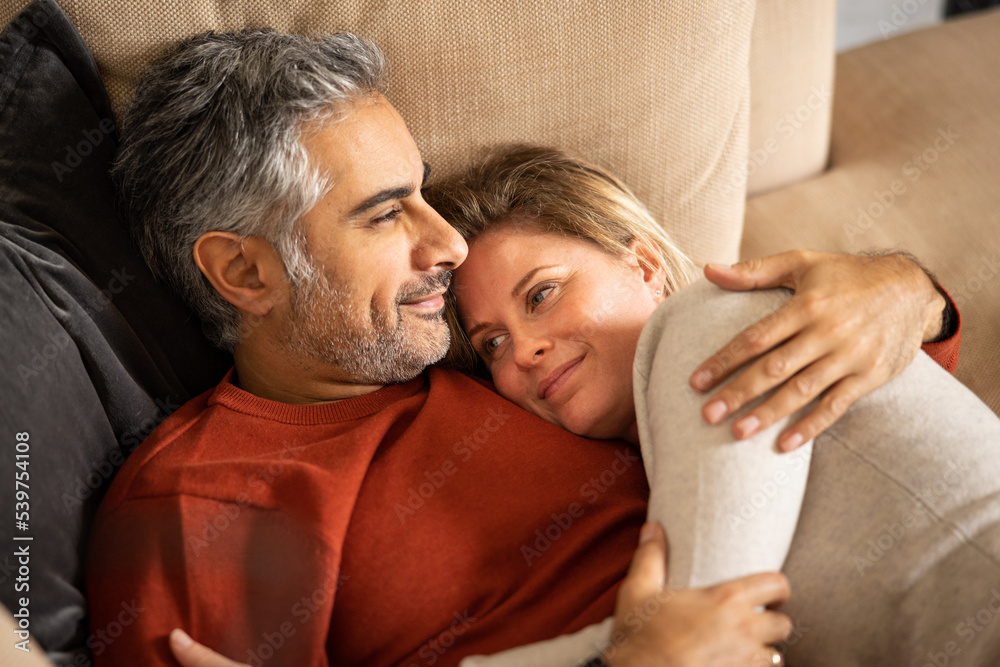 Close up of couple embracing on the couch Close up of couple embracing on the couch