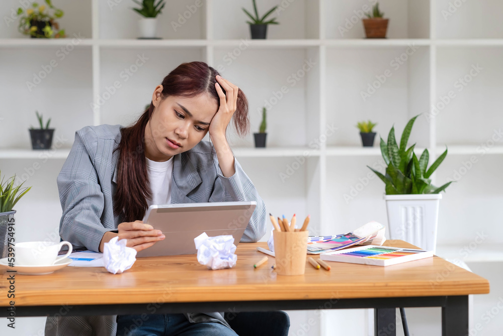 Stressed Asian businesswoman unsatisfied with her work, using portable tablet to check her email, receiving a bad email from her boss, getting a complained from customer. Stressed Asian businesswoman unsatisfied with her work, using portable tablet to check her email, receiving a bad email from her boss, getting a complained from customer.