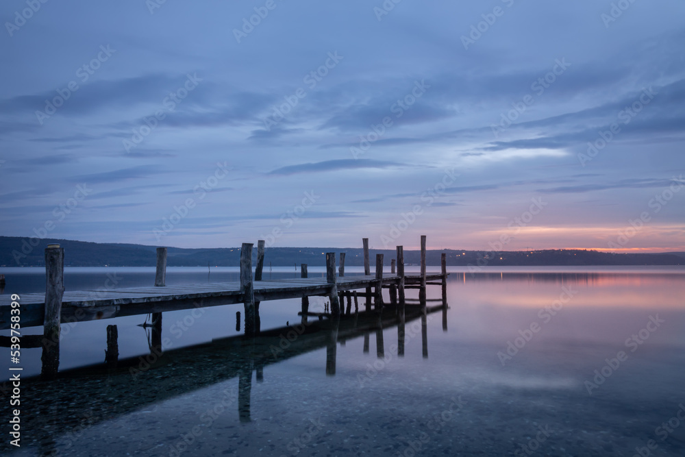 Magnificent sunset wooden Pier on the lake. A tranquil sunset over a Varna lake.