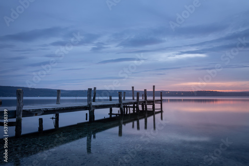 Magnificent sunset wooden Pier on the lake. A tranquil sunset over a Varna lake. © dechevm