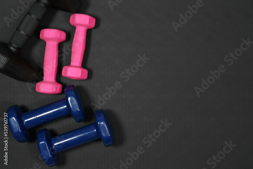 pink and black blue dumbbell background on black rubber background.fitness equipment background concept