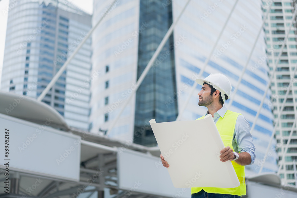Fototapeta premium Man engineer standing on construction site. Engineer working on outdoor project