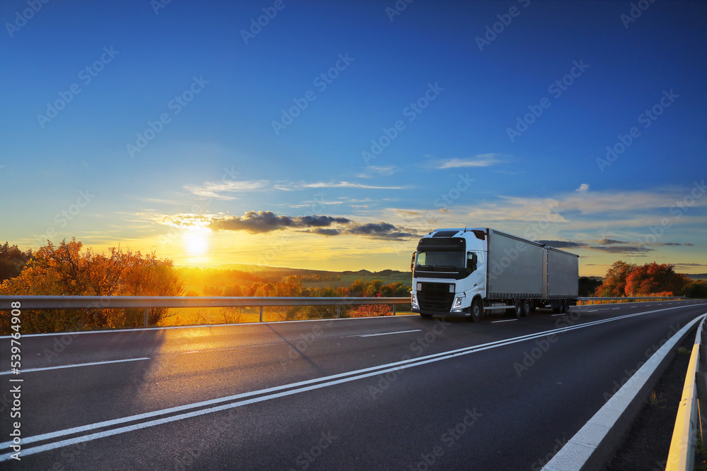 Truck transport on the road at sunset and cargo