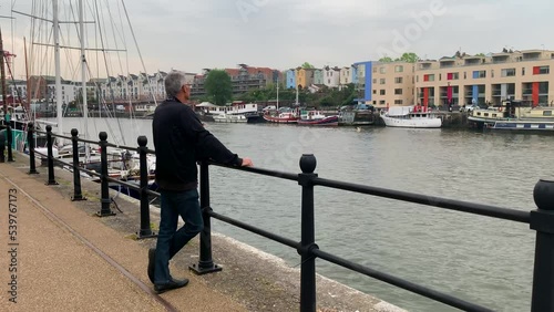 Mature man watching boats at Bristol Harbour