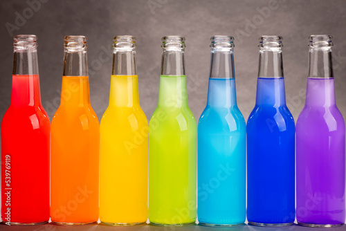 Rainbow colors in bottles. Colorful rainbow background. Drinks lined up.
