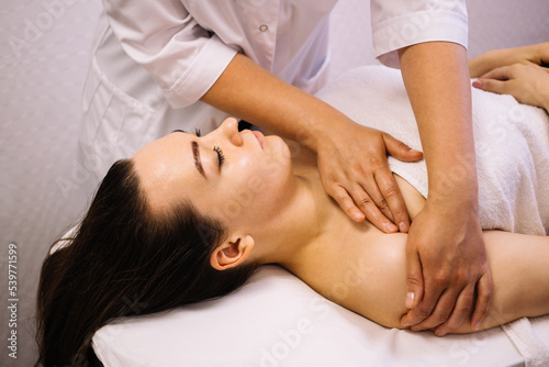 Woman receiving facial massage in beauty salon.Beauty and skincare concept with a beautiful woman. Middle aged female relaxed with massage for facial lifting