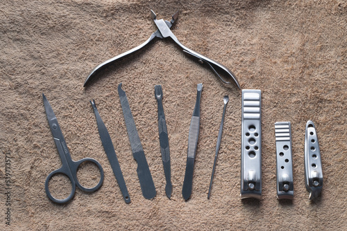 Fotografi Manicure nails and pedicure tool set on soft brown towel concept, cosmetic acces