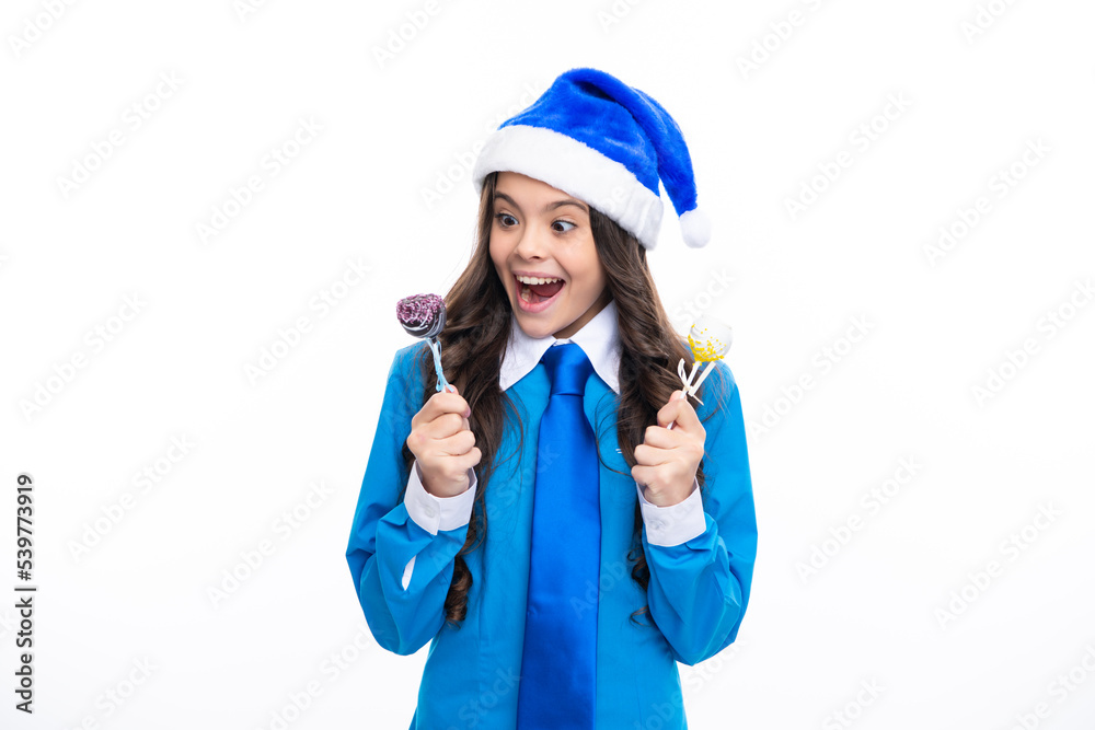 Excited girl hold christmas sweets lollipop. Child girl on christmas new year isolated in white studio background. Teenager in santa hat. Blue christmas costume. Amazed expression, cheerful and glad. Excited girl hold christmas sweets lollipop. Child girl on christmas new year isolated in white studio background. Teenager in santa hat. Blue christmas costume. Amazed expression, cheerful and glad.