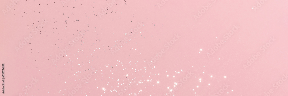 Sparkling silver glitter on pink background banner texture. Abstract holiday blurred lights header. Wide screen wallpaper. Panoramic web banner with copy space for design