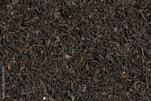 Large dry leaves of black tea. Black tea background. Black tea texture
