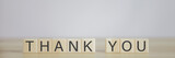 Wooden block showing a message, the word thank you.