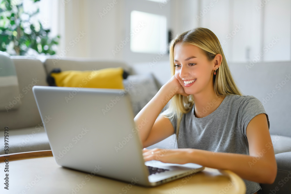 Happy teenager girl online with a laptop in the living room at home Happy teenager girl online with a laptop in the living room at home