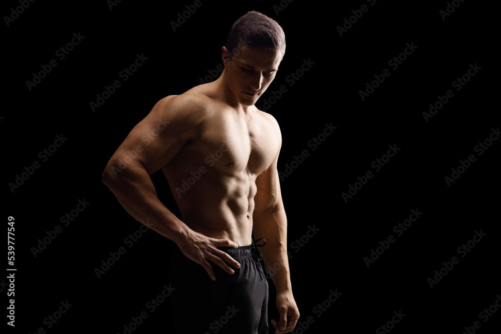 Fototapeta premium Topless young muscular man isolated on black