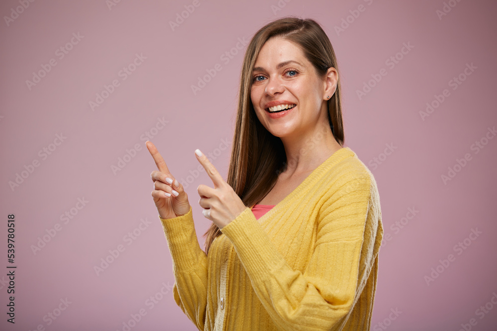 Smiling woman in yellow sweater pointing fingers up. Advertising fefemale portrait. Smiling woman in yellow sweater pointing fingers up. Advertising fefemale portrait.