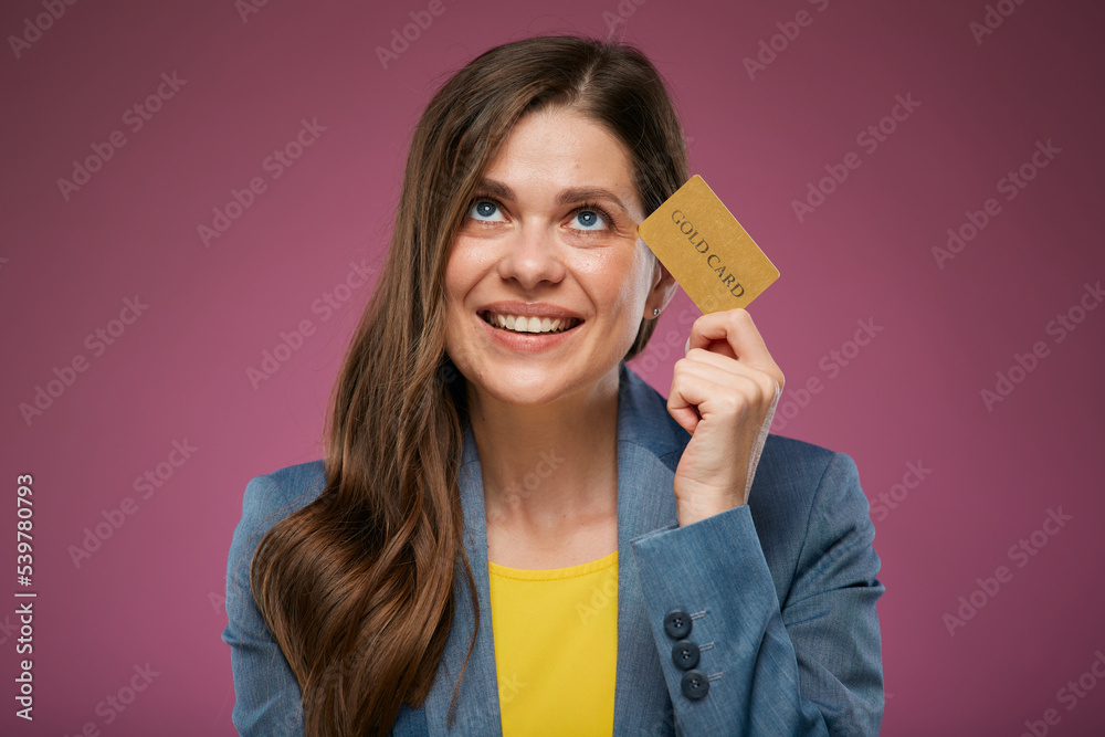 Happy woman looking up holding credit card. Isolated advertising portrait on pink back. Happy woman looking up holding credit card. Isolated advertising portrait on pink back.