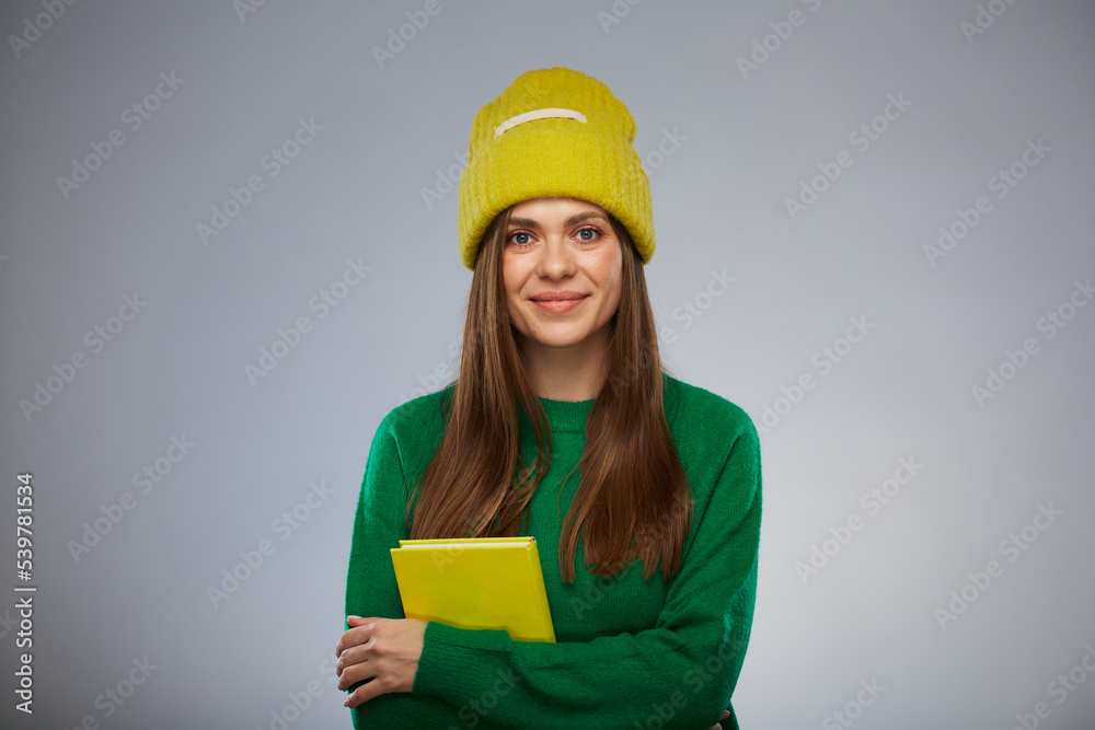 Smiling student dressed in casual teenage style holding book. Advertising female studio portrait. Smiling student dressed in casual teenage style holding book. Advertising female studio portrait.