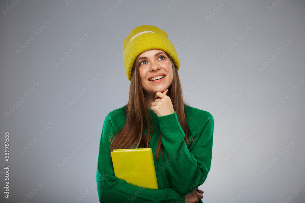 Thinking student dressed in casual teenage style holding book. Advertising female studio portrait. Thinking student dressed in casual teenage style holding book. Advertising female studio portrait.
