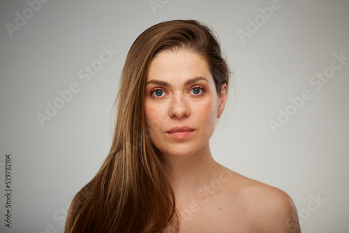 Portrait of young woman with bare shoulders and long hair. Isolated studio advertising portrait.