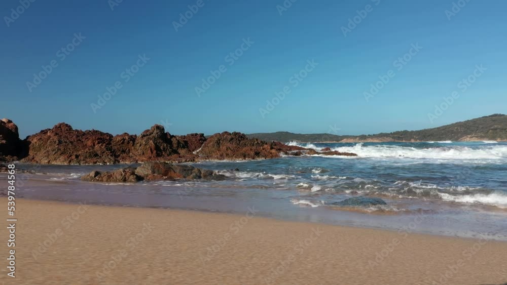 Low angle view of sand beach and waves at sunset in Corsica. Stabilized high quality color graded footage Low angle view of sand beach and waves at sunset in Corsica. Stabilized high quality color graded footage