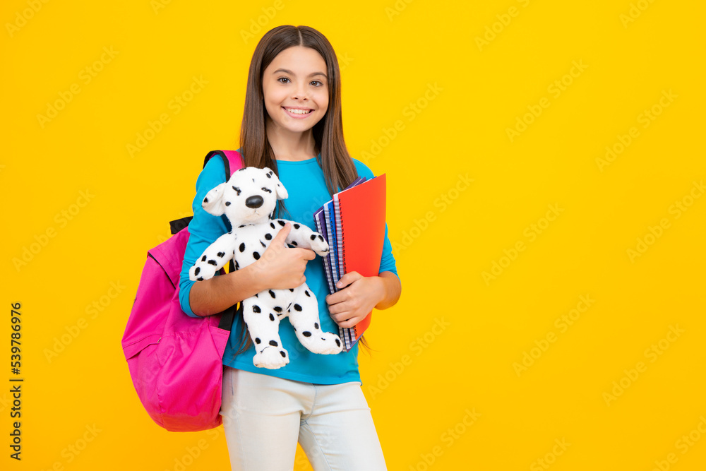 Happy teenager portrait. Schoolgirl 12, 13, 14 years old with toy. School children cuddling favorite toys on yellow background. Happy childhood. Smiling girl. Happy teenager portrait. Schoolgirl 12, 13, 14 years old with toy. School children cuddling favorite toys on yellow background. Happy childhood. Smiling girl.