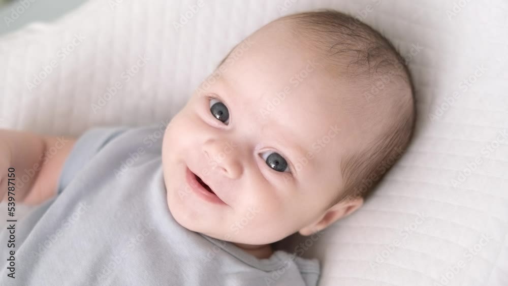 Portrait newborn baby boy lying in nursery cocoon with blue clothes on bed in bedroom at home, happy baby morning Portrait newborn baby boy lying in nursery cocoon with blue clothes on bed in bedroom at home, happy baby morning