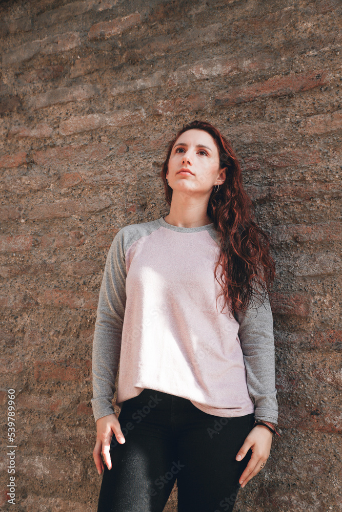 woman leaning on stone wall looking at the sky woman leaning on stone wall looking at the sky