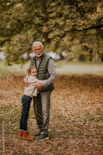 Grandfather spending time with his granddaughter in park on autumn day © BGStock72