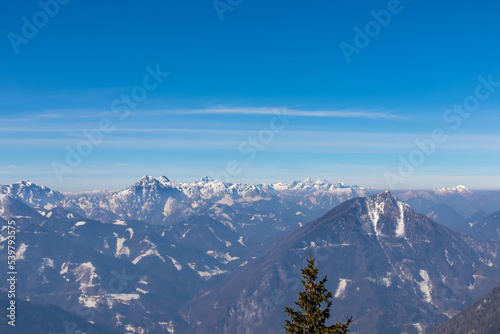 Scenic view on snow capped mountain peaks of Karawanks in Carinthia  Kaernten   Austria. Julian Alps. Winter wonderland in Austrian Alps  Europe. View from Freiberg on Hochstuhl  Stol   Triglav  Kepa