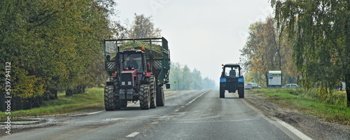 Tractors on village asphalted road in work . Farming transport