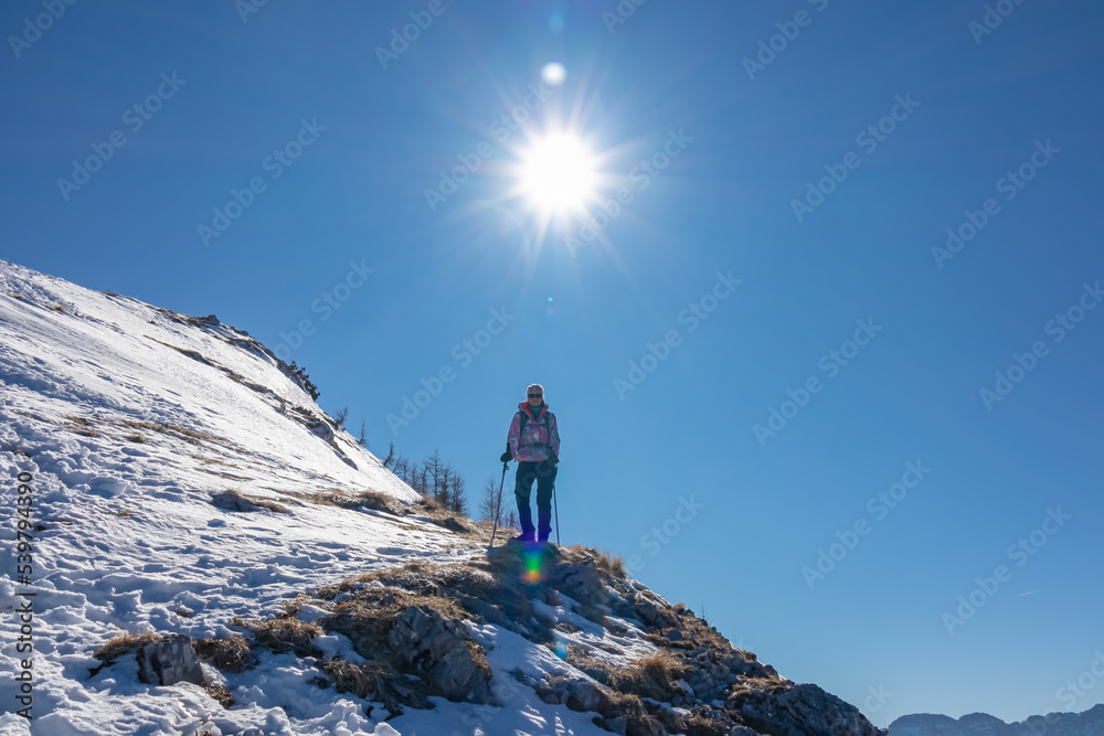 Woman on a snow shoe track leading to mountain summit Freiberg near Zell Pfarre (Sele), Austrian Alps, Carinthia (Kaernten), Austria, Europe. Winter wonderland on sunny day in Karawanks, Julian Alps