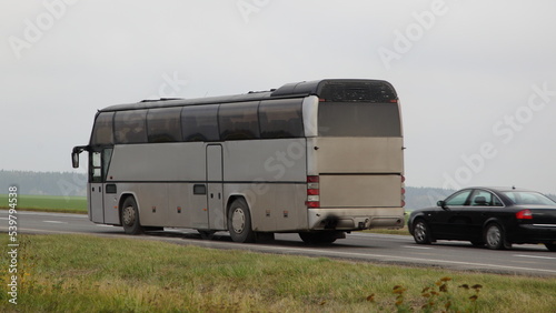 Old gray passenger bus overtake a car on highway closeup . Passenger transportation safety