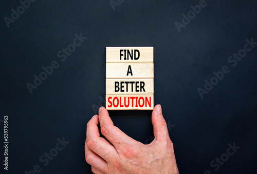 Find a better solution symbol. Concept words Find a better solution on wooden blocks. Beautiful black table black background. Businessman hand. Business find a better solution concept. Copy space.