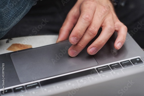 Close up hand of man scrolling a Website Using Laptop Track Pad. Computer keyboard. Using Touchpad Of Laptop.