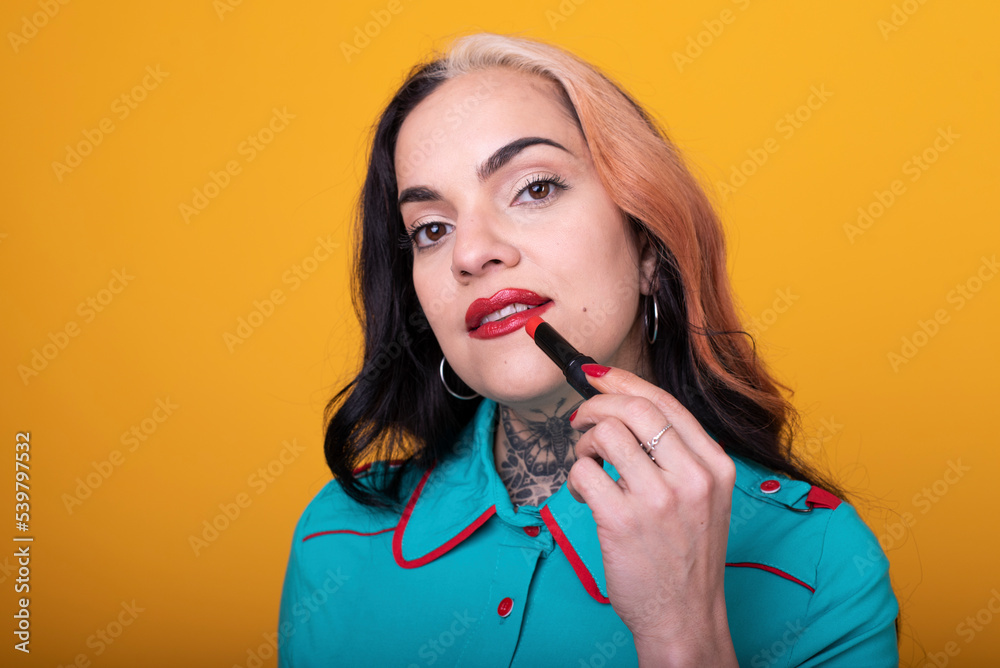 Beautiful caucasian woman applying a bright red color lipstick on her lips Beautiful caucasian woman applying a bright red color lipstick on her lips