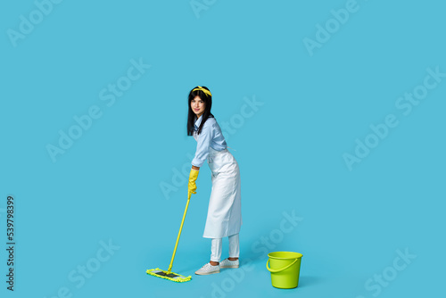 woman in rubber gloves and cleaner apron with cleaning supplies © producer