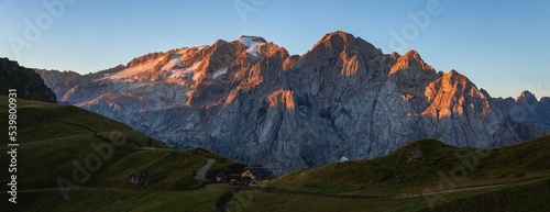 View of the Marmolada, the highest peak of the Dolomites, with its glaciers and the morning light, near the town of Canazei, Italy - August 2022.