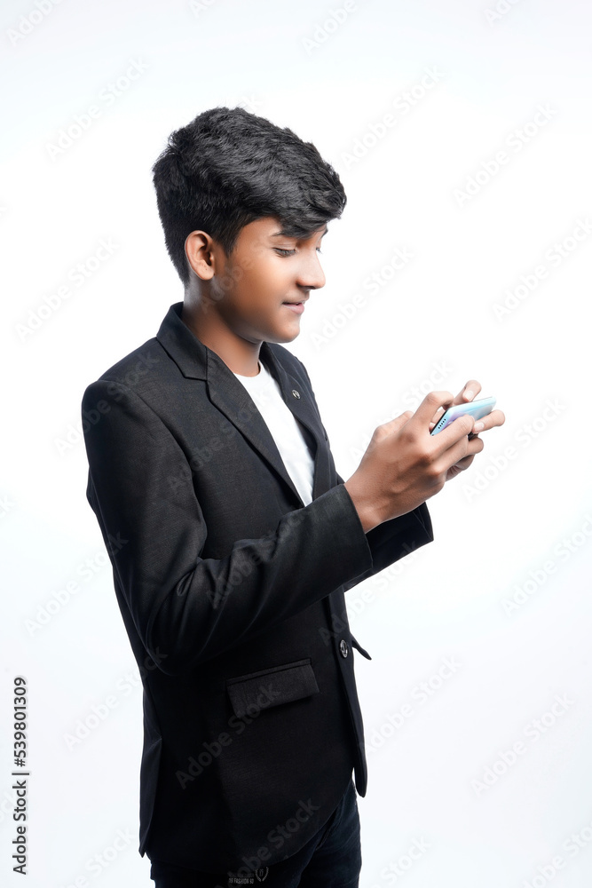 Happy handsome indian man wearing ethnic outfit holding or using mobile phone celebrating diwali festival and giving expression Happy handsome indian man wearing ethnic outfit holding or using mobile phone celebrating diwali festival and giving expression