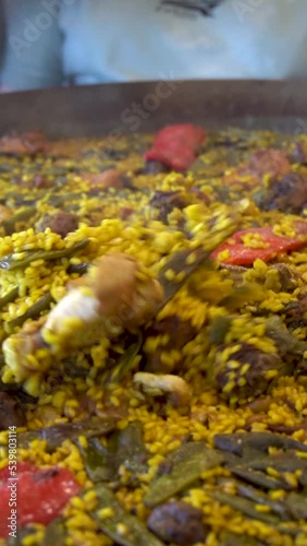  Slow moton, close up metallic spoon moving a valencian paella photo